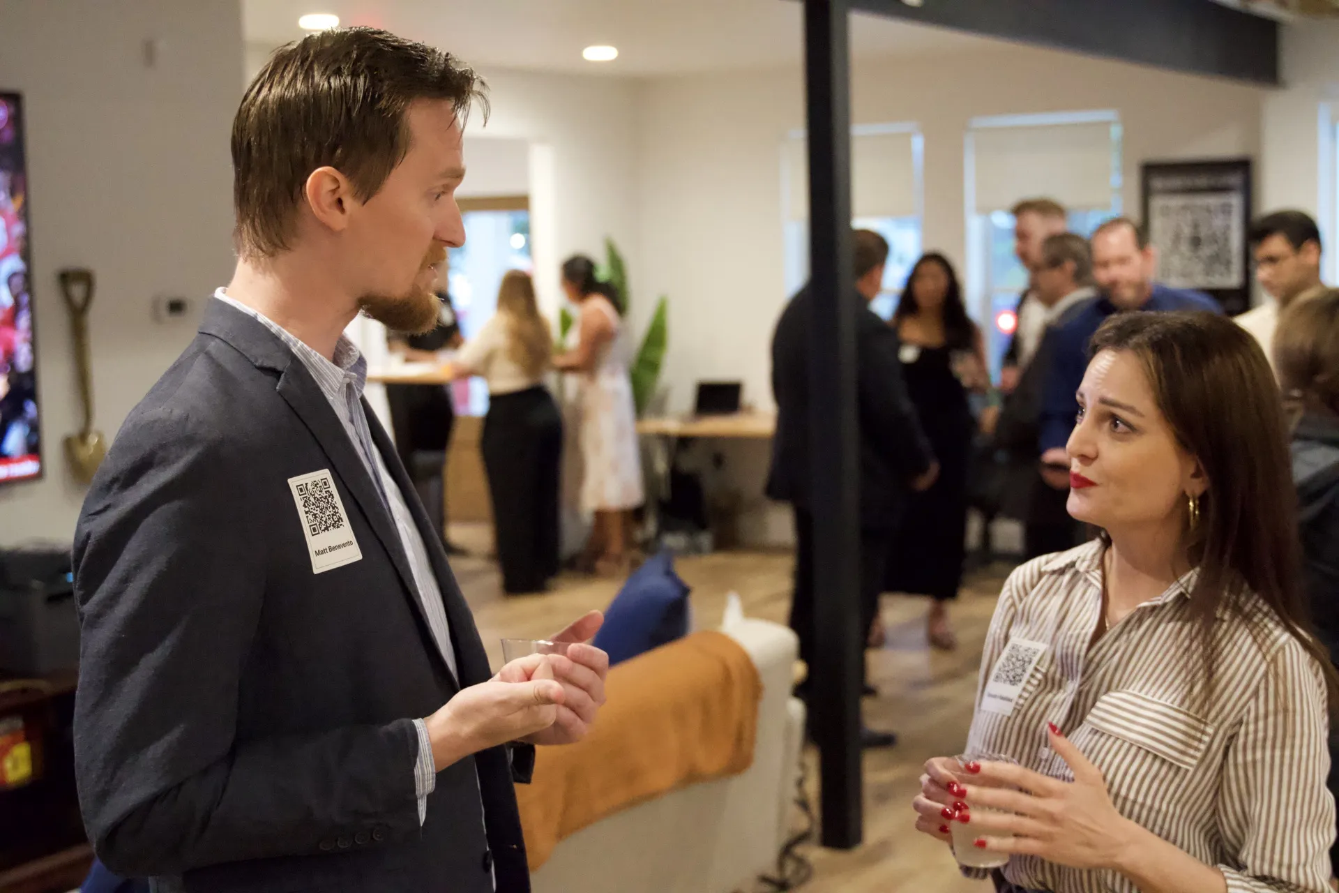 Two guests talking with other attendees gathered behind them at a Capitol Keys event